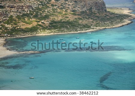 Bird\'s eye view of the Cretan seashore. Little boats drifting on the beautiful azure water.