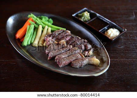 japanese food beef steak and sauce with dark brown wood pattern