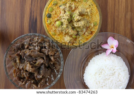 Thai food beef curry and sweet pork with rice in wood background