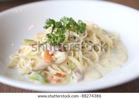 Spaghetti with mushroom and ham white sauce on wood background