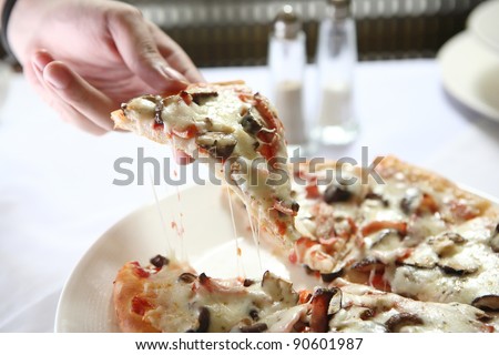 Pizza ham ans mushroom slice lifted with cheese strings