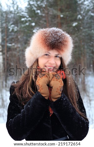 freezing girl in winter clothes covered with snowflakes