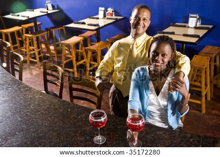 Young African couple having drinks in a restaurant