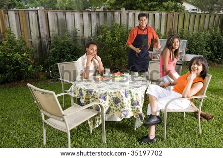 Interracial family having back yard barbecue