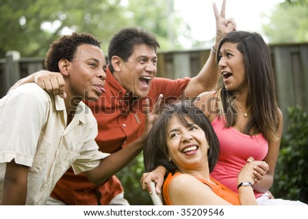 Interracial family making silly gestures posing for photograph