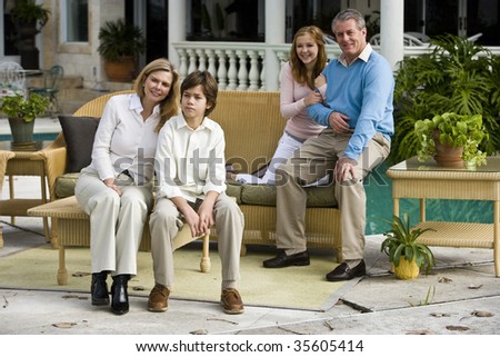 Portrait of family with two children sitting on patio