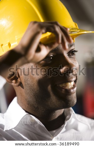 Face of young African American man in hard hat smiling