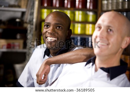 Coworkers in printing shop by shelves with inks