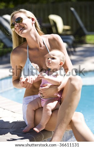 Mother with six month old baby next to a swimming pool