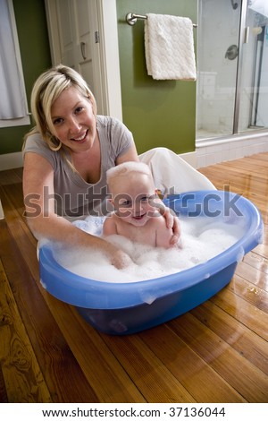 Happy mother bathing her cute 7 month old baby