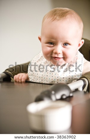 Six month old baby in high chair ready to eat