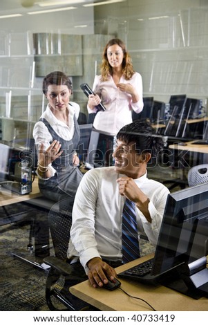 Three university students conversing in library computer room