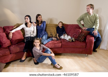 Portrait of family sitting on couch with father and teen daughter having disagreement