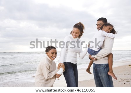 Happy African-American family with two children on beach