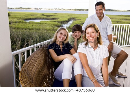 Family with teenager children on vacation sitting together on terrace