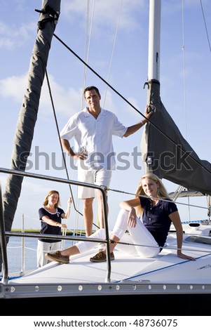 Teenage girl and parents relaxing on sailboat at dock on sunny day