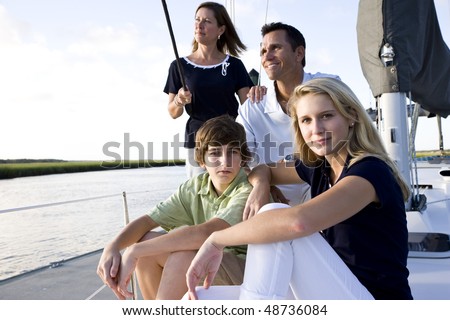 Family with teenage children sitting on boat at dock on sunny day