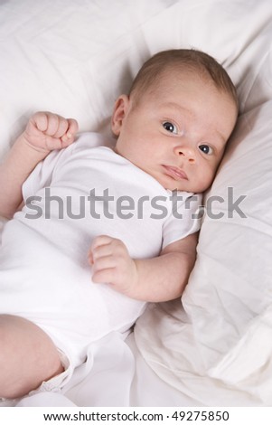 One month old newborn baby boy lying on white pillow