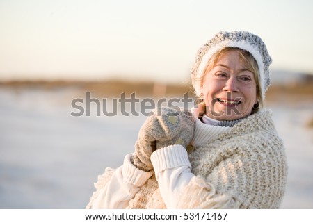 Portrait of senior woman wearing warm winter hat, sweater and gloves