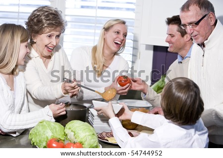 Grandmother with family cooking in kitchen, smiling and laughing together