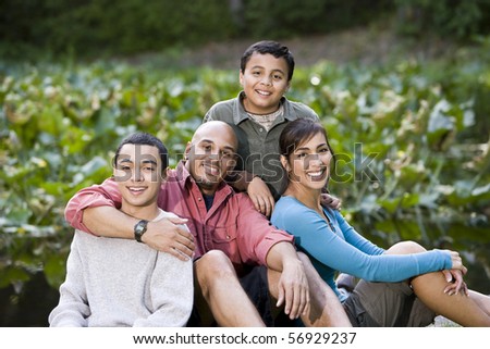 Portrait of happy Hispanic family with two boys outdoors