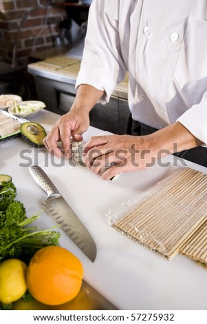 Professional Japanese chef in restaurant making sushi rolls