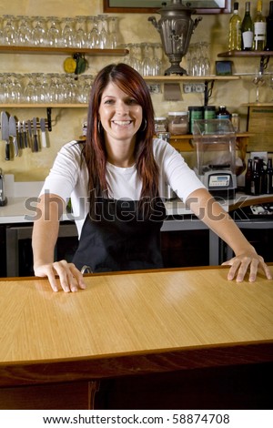 Friendly waitress standing behind counter in restaurant