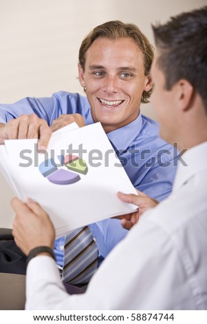 Businessmen discussing financial results looking at pie chart