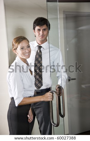 Two business people at door of office boardroom