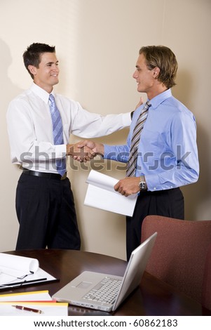 Two businessmen meeting in office shaking hands