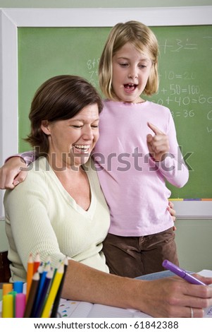 Back to school - teacher teaching 8 year old student in classroom
