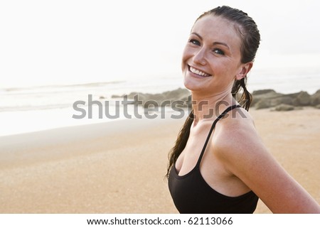Portrait of beautiful young woman wearing bikini smiling on beach
