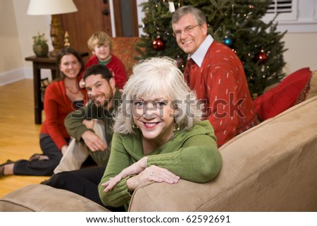 Senior woman with family by Christmas tree - three generations