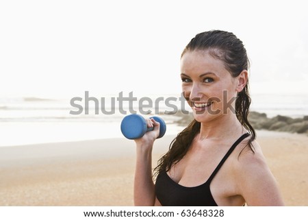 Portrait of beautiful young woman exercising on beach