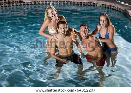 Young adults (20s) having fun in swimming pool at night
