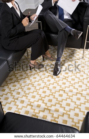 Cropped view of man and woman in business suits talking and reviewing report