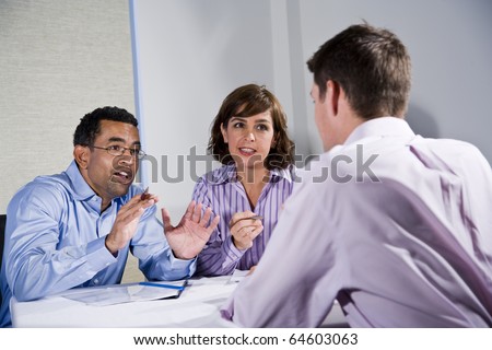 Multiracial business meeting in boardroom, sitting at a table