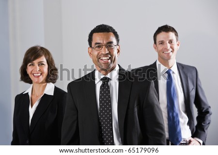 Businesspeople standing in office, focus on African American businessman, 40s