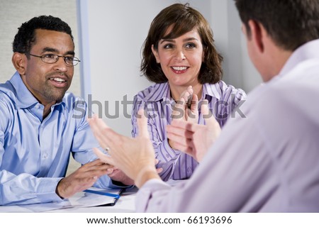 Multiracial business meeting in boardroom, sitting at a table