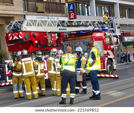 GENEVA, SWITZERLAND, AUG 22 : Firemen and medical team next to firetruck discussing intervention in Geneva, Switzerland, on August 22 2014.