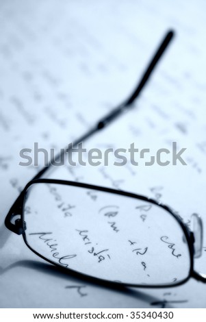 Glasses placed on a sheet of hand written paper