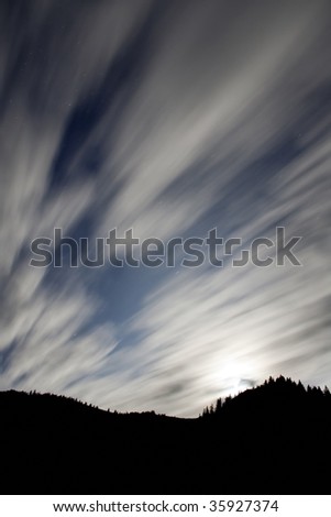 Shining moon over mountain and moving clouds