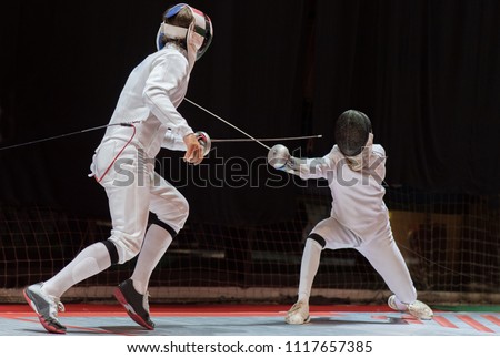 Two man fencing athletes fight on professional sports arena
