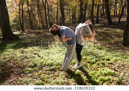 girl and man doing yoga meditation in a forest