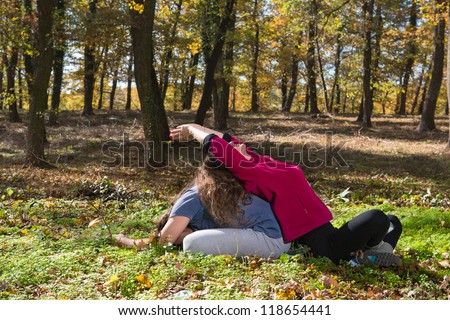 Couple doing yoga meditation in a forest