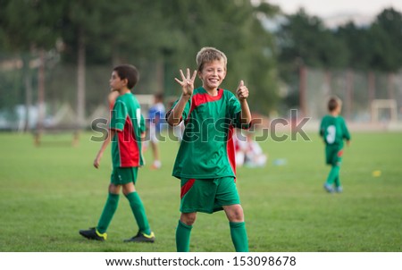 little boy showing result on football match