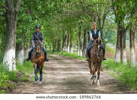 Two a young girls on horseback riding
