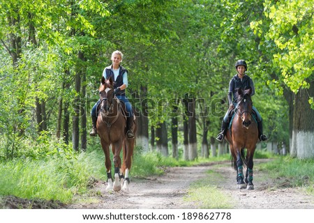 Two a young girls on horseback riding