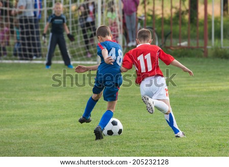 boys kicking football on the sports field boys kicking football on the sports field