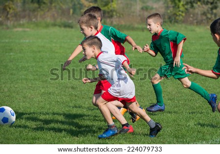 boys kicking football on the sports field boys kicking football on the sports field